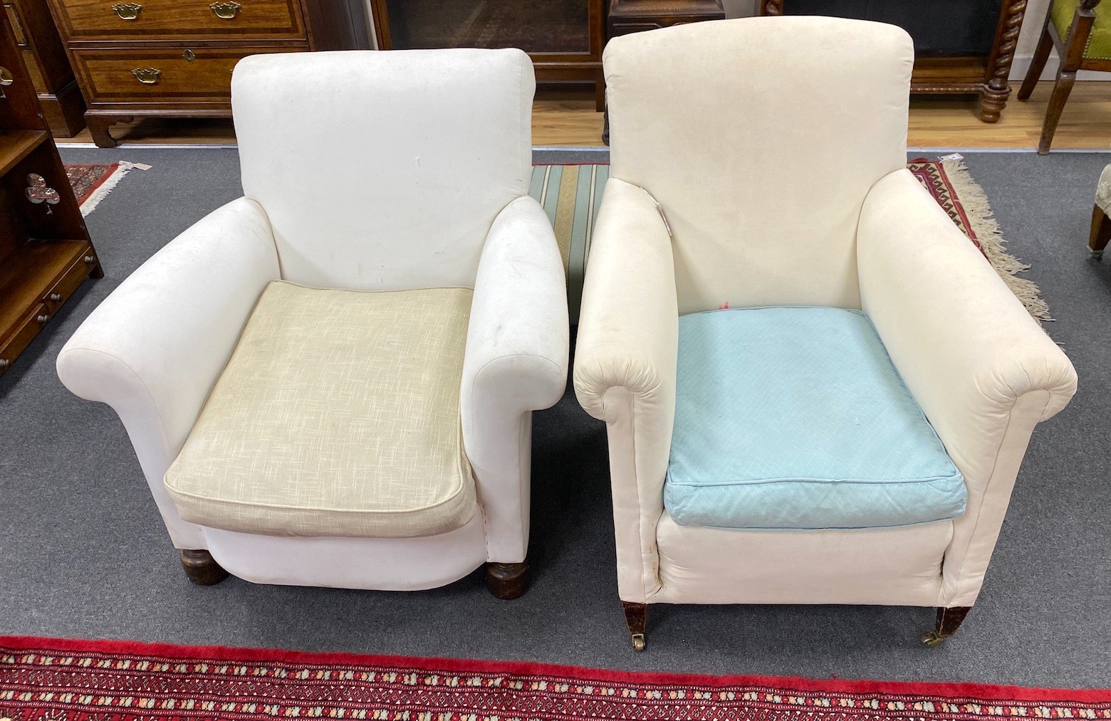 Two early 20th century upholstered armchairs, back legs stamped Howard & Son, Berners St and Howard & Son London. One castor marked H&S, larger width 76cm, depth 86cm, height 79cm